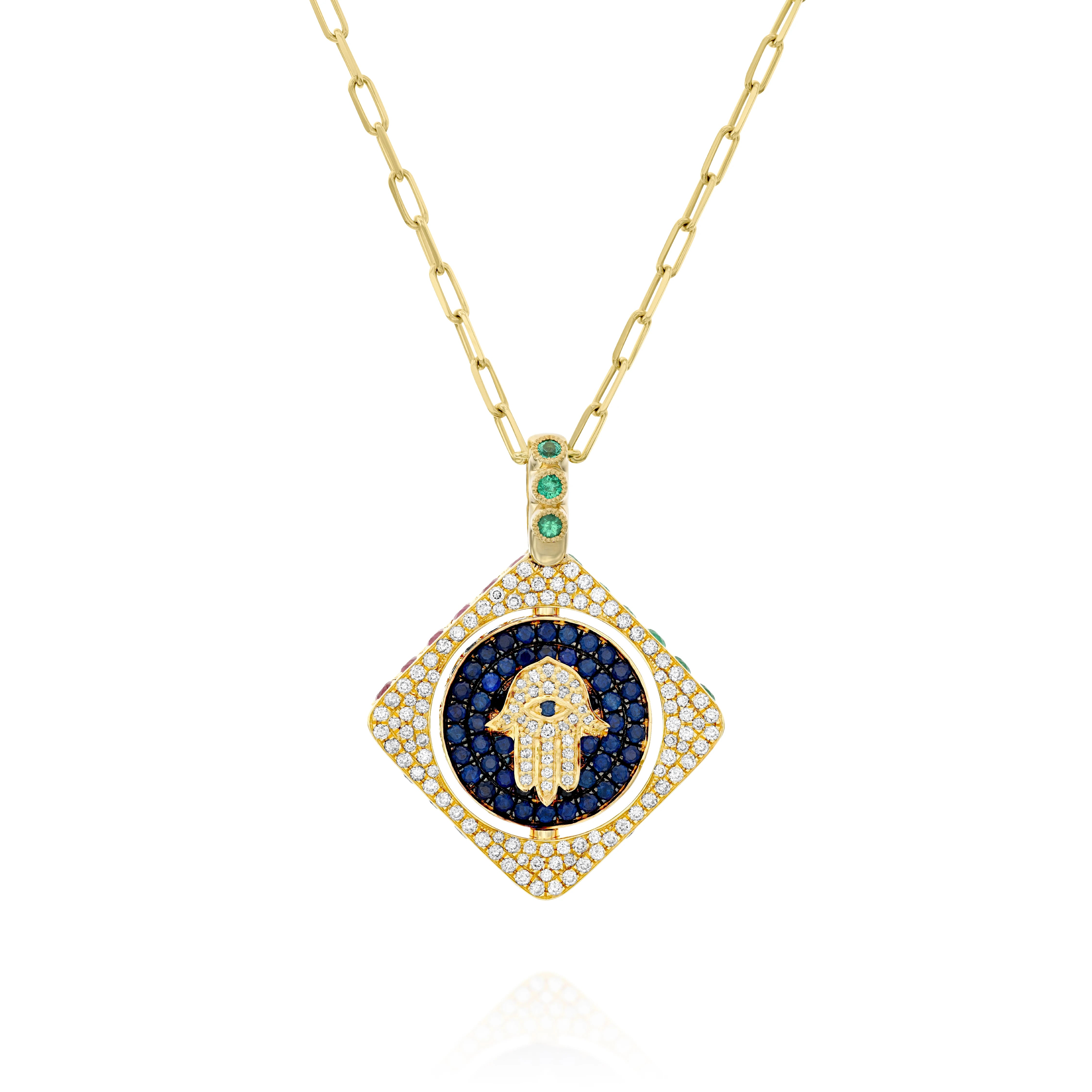 18k gold double-sided spinning pendant featuring a circle within a square design with a protective Hamsa motif. Set with diamonds, sapphires, rubies, and emeralds, this unique piece transforms its appearance with each turn, offering multiple looks in one stunning jewel. The pendant combines traditional protective symbolism with modern luxury design.
