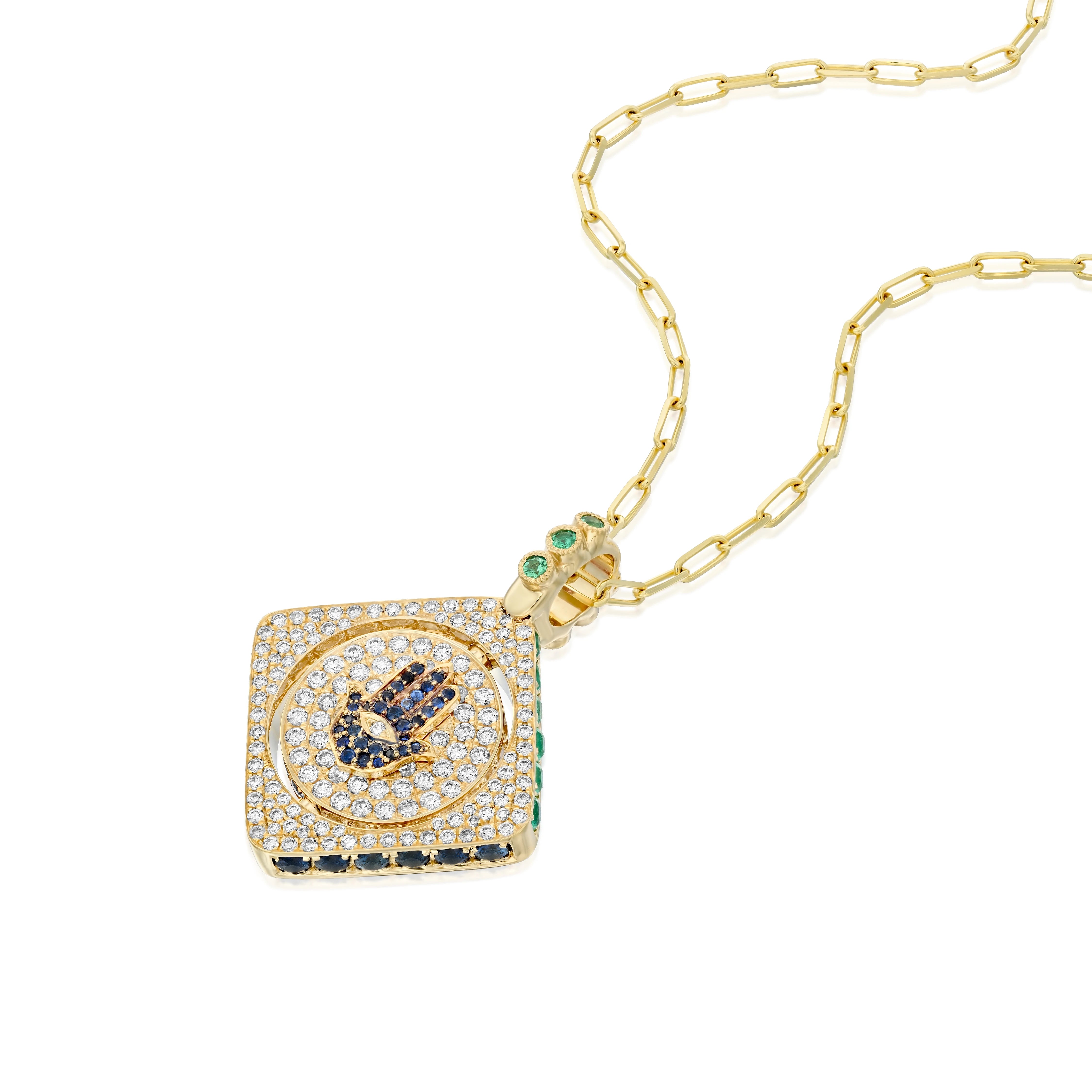 18k gold double-sided spinning pendant featuring a circle within a square design with a protective Hamsa motif. Set with diamonds, sapphires, rubies, and emeralds, this unique piece transforms its appearance with each turn, offering multiple looks in one stunning jewel. The pendant combines traditional protective symbolism with modern luxury design.