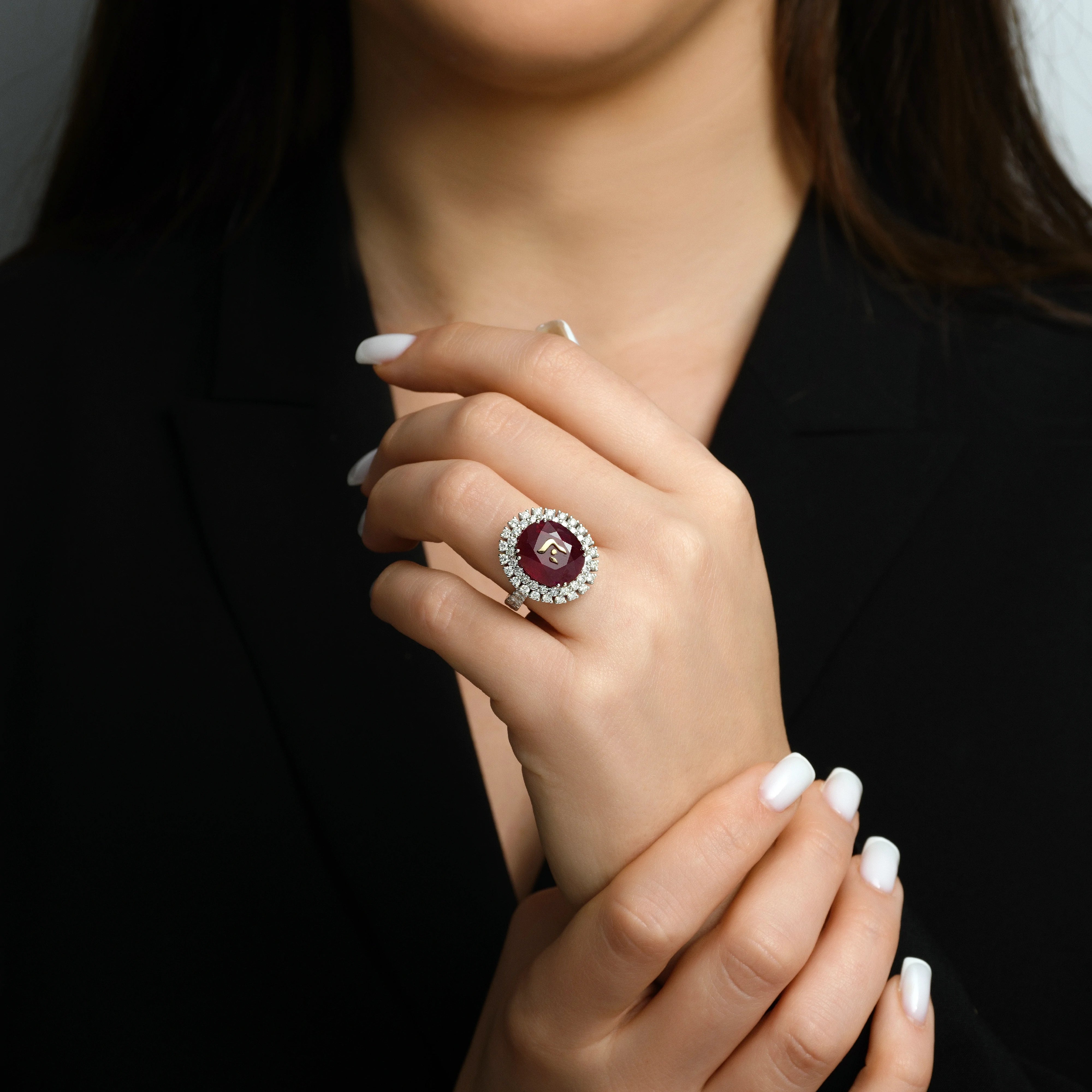 A ruby ring set in 18k white gold adorned with the Hebrew letter “Hei” (‘ה).