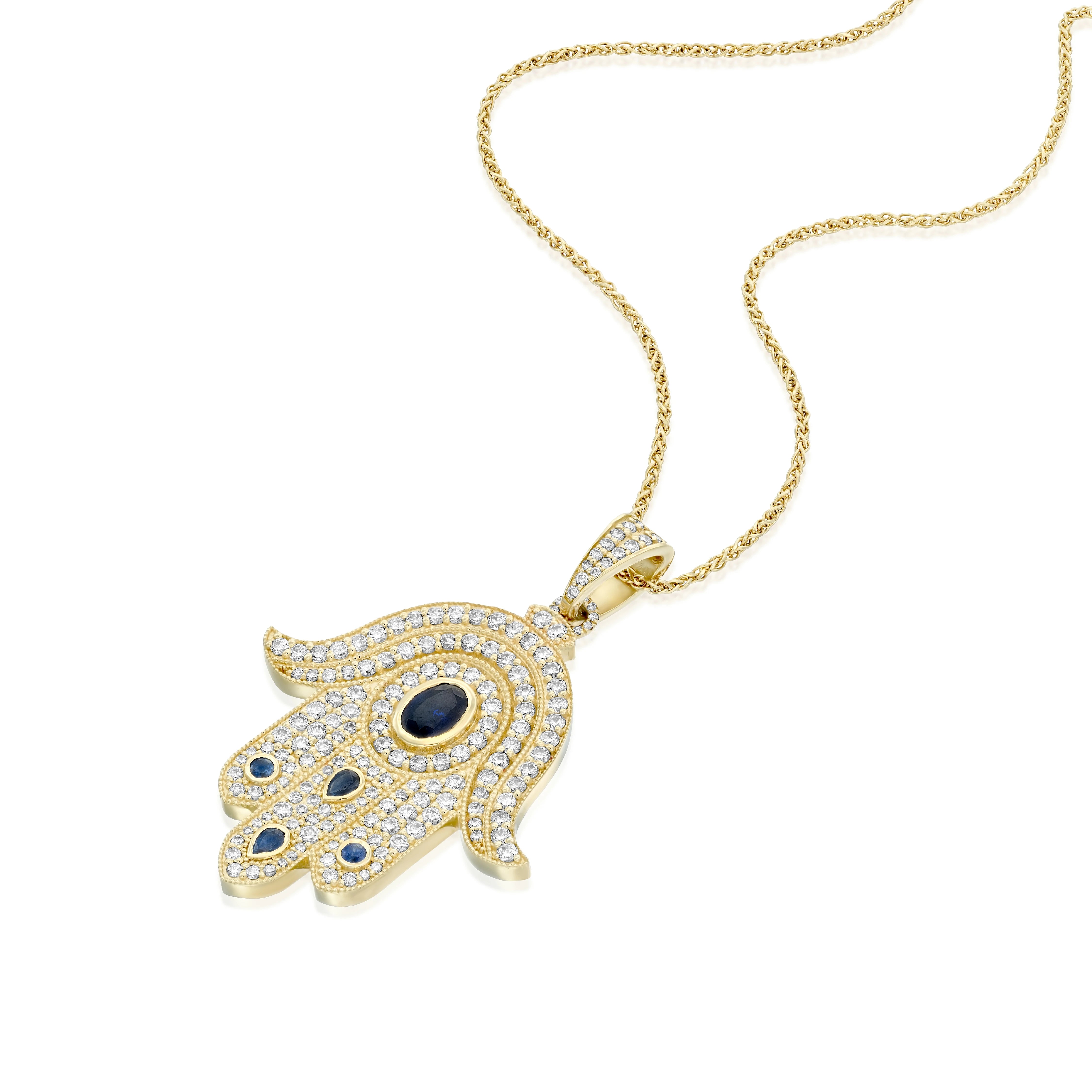 A yellow gold Hamsa pendant set with round brilliant diamonds and
sapphires. At the heart of the pendant lies a round sapphire symbolizing
the compassionate Guardian Eye ( against the Evil Eye ) , that always
carefully watches over and protects us. The fusion of the numerous
precious stones with the traditional Hamsa shape creates a pendant that
captivate every heart.