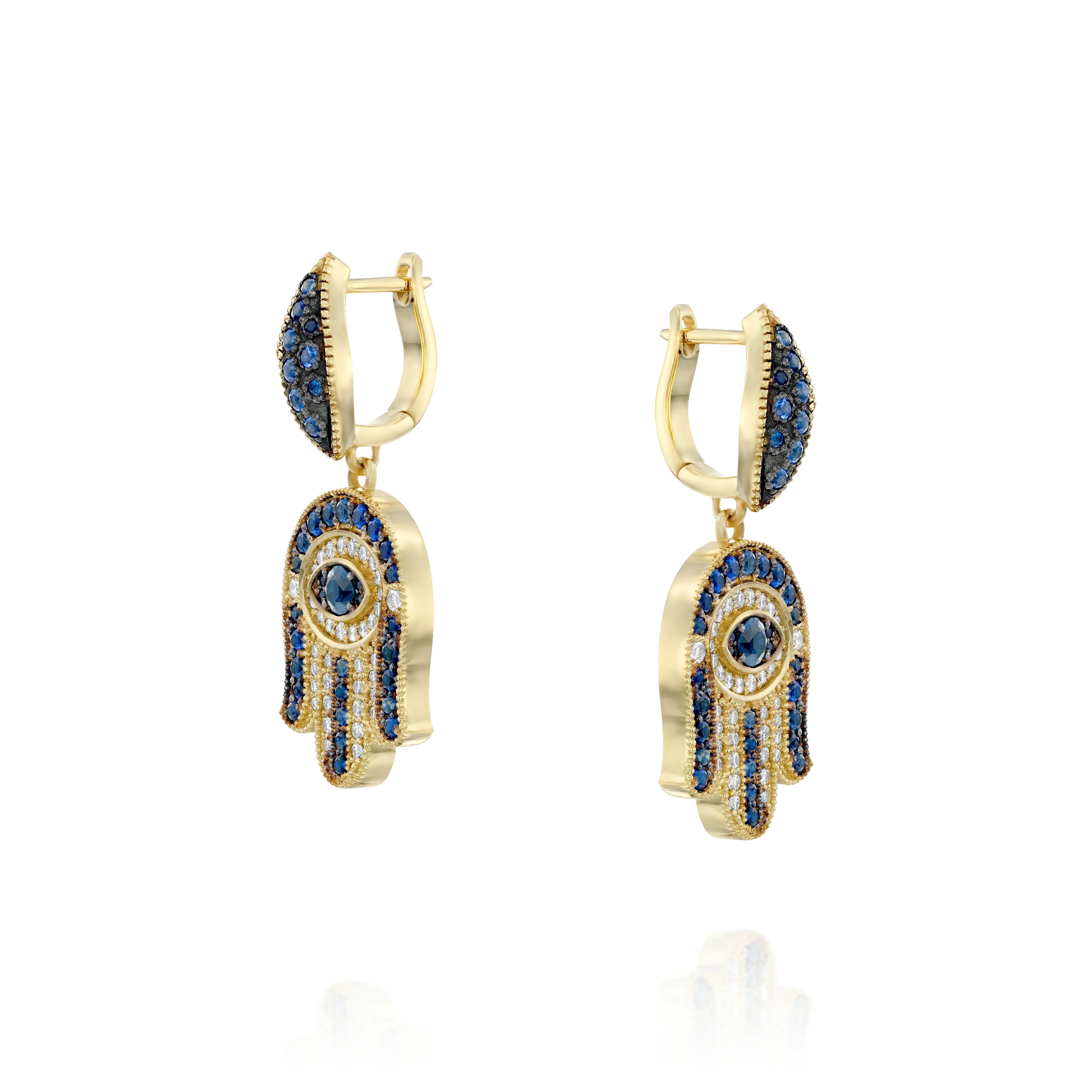 Hamsa gold earrings set with round brilliant diamonds and sparkling
sapphires. At the heart of each earing lies the compassionate Guardian
Eye (against the Evil Eye) that always carefully watches over and
protects us .Exceptional earrings that harmoniously blend oriental and
western elements.