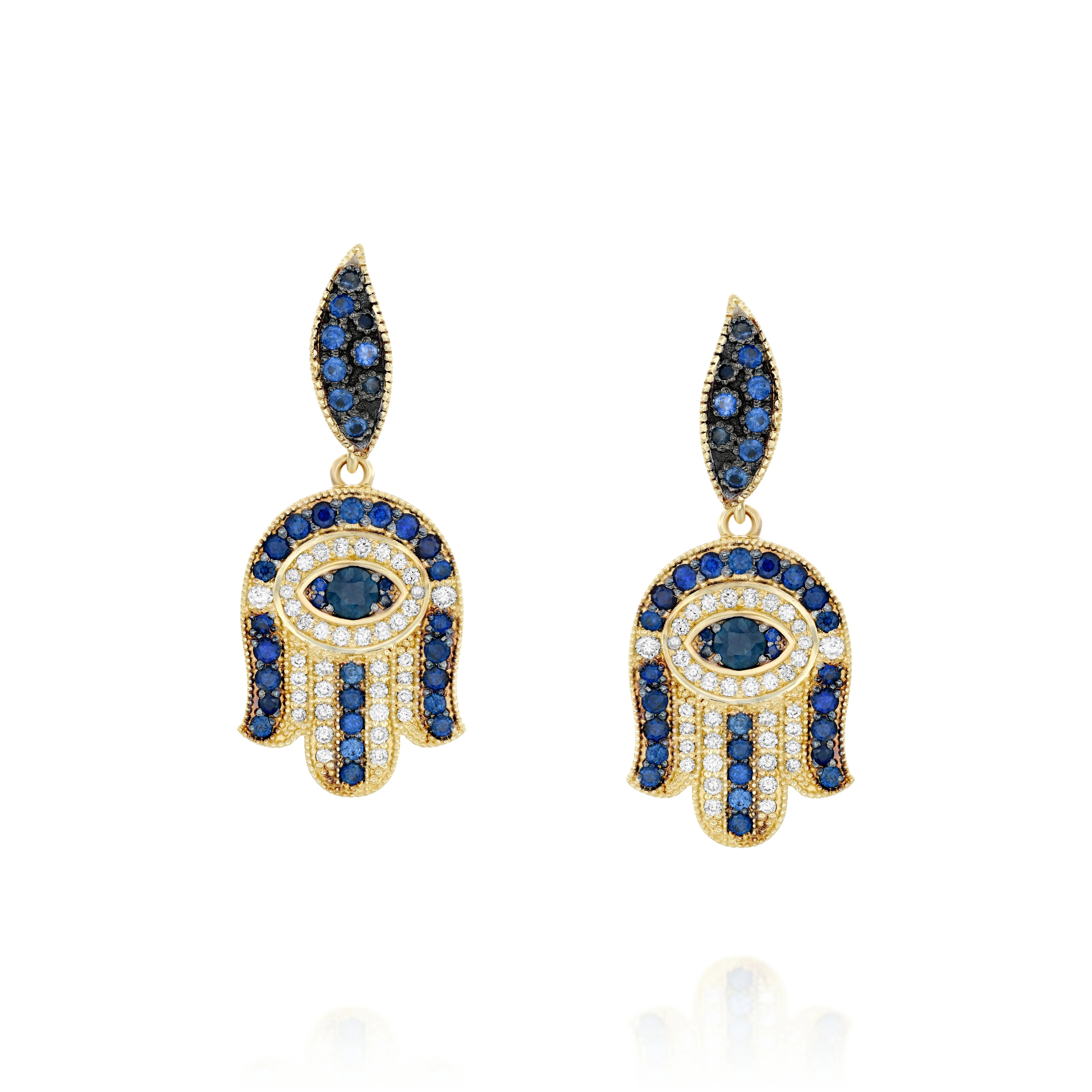 Hamsa gold earrings set with round brilliant diamonds and sparkling
sapphires. At the heart of each earing lies the compassionate Guardian
Eye (against the Evil Eye) that always carefully watches over and
protects us .Exceptional earrings that harmoniously blend oriental and
western elements.