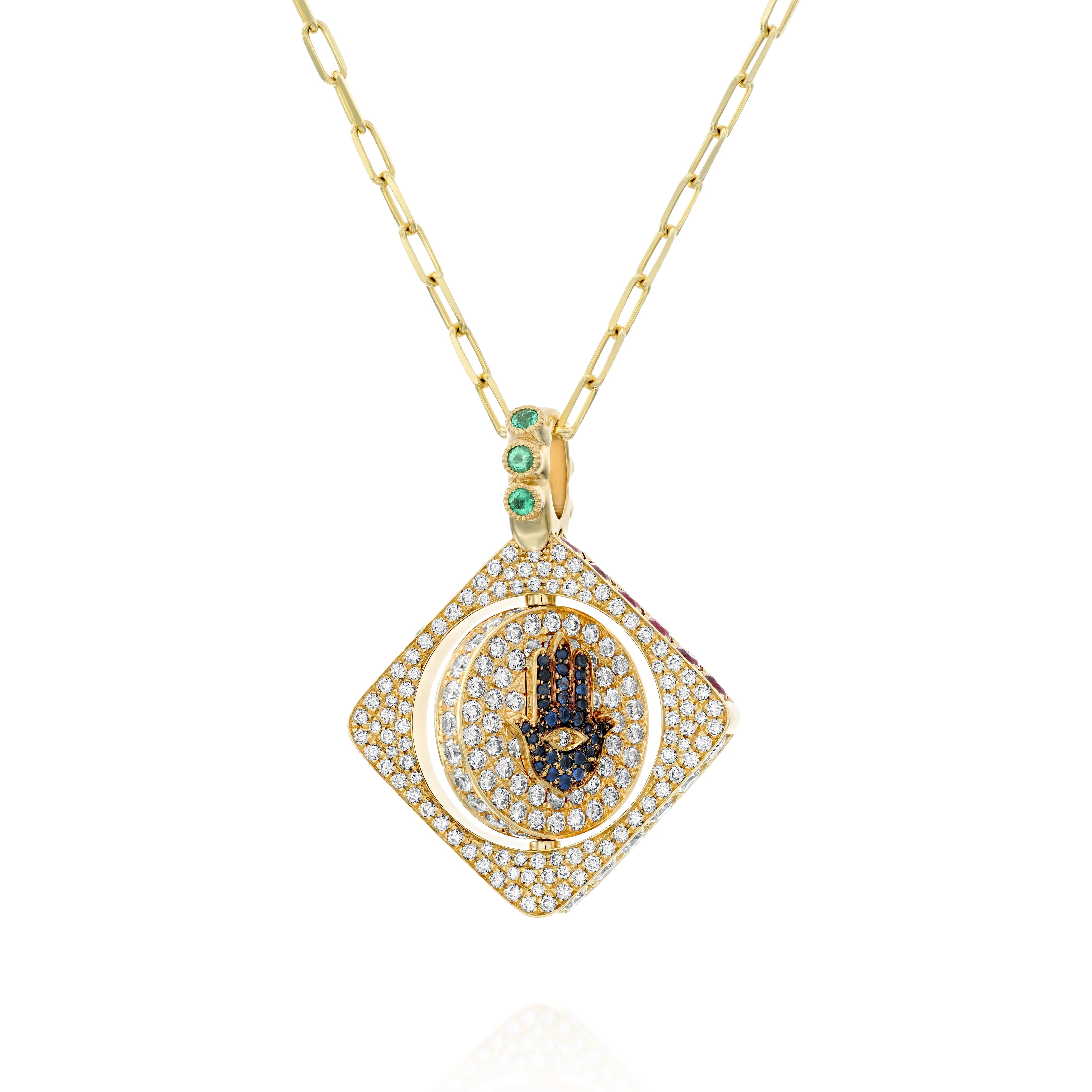 18k gold double-sided spinning pendant featuring a circle within a square design with a protective Hamsa motif. Set with diamonds, sapphires, rubies, and emeralds, this unique piece transforms its appearance with each turn, offering multiple looks in one stunning jewel. The pendant combines traditional protective symbolism with modern luxury design.