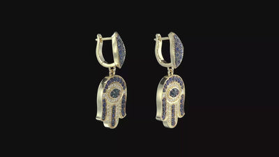 Video hamsa gold earrings set with round brilliant diamonds and sparkling
sapphires. At the heart of each earing lies the compassionate Guardian
Eye (against the Evil Eye) that always carefully watches over and
protects us .Exceptional earrings that harmoniously blend oriental and
western elements.